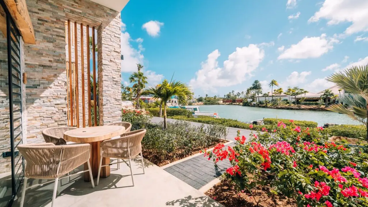 Terras van een Deluxe Room Double King Bed van Van der Valk Bonaire met bloeiende bougainville en zicht op de lagune