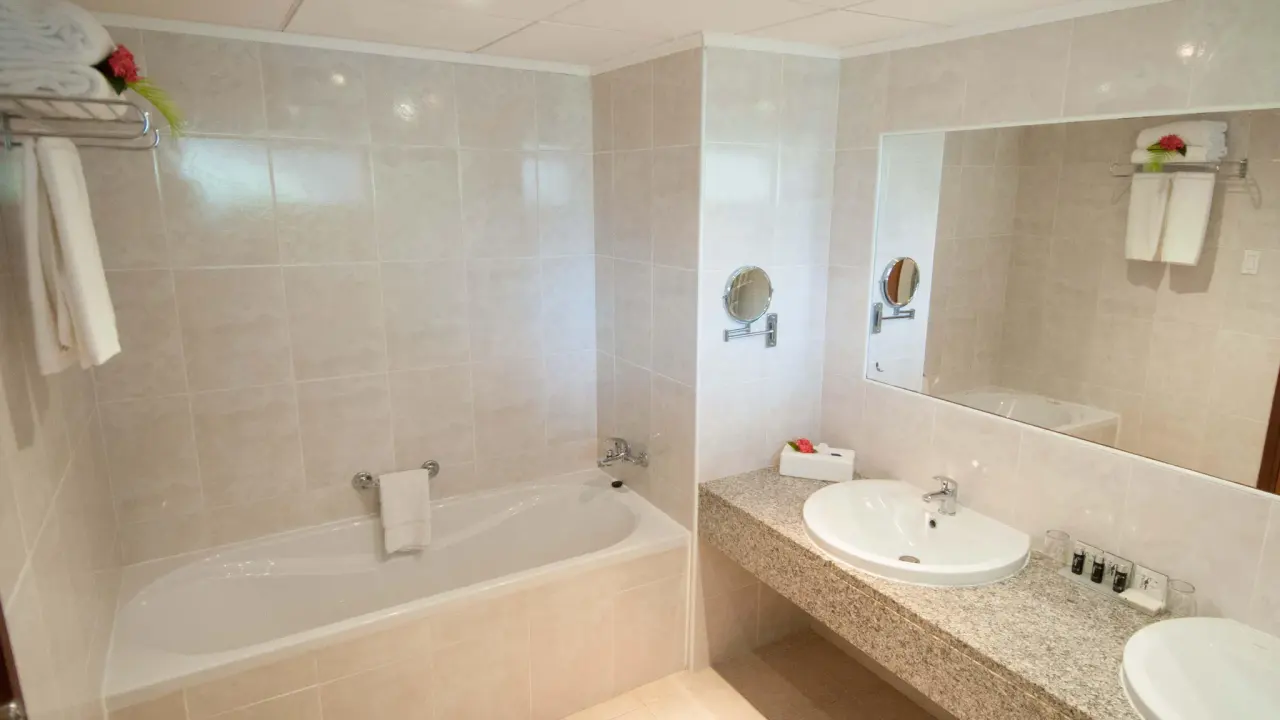 Oudere badkamer met ligbad in een Junior Suite Poolside van Van der Valk Bonaire