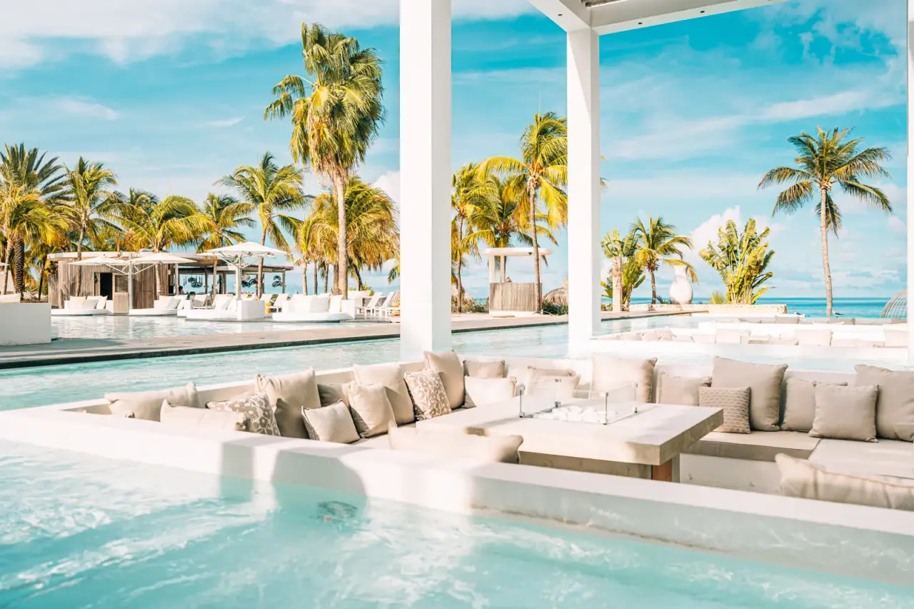 Verzonken lounge in het zwembad van Van der Valk Bonaire met uitzicht op palmen en zee